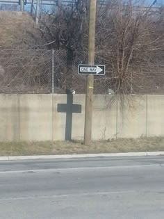 a street sign on the side of a road next to a fenced in area