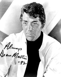 an old black and white photo of a man in a lab coat with his hand on his chest