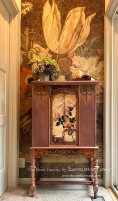 a painting on the wall behind a cabinet