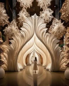 a woman is standing in front of an intricately designed entrance to a building with snowflakes hanging from the ceiling