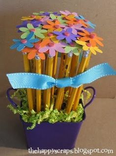 a bunch of pencils that are in a purple cup with flowers on it and blue ribbon