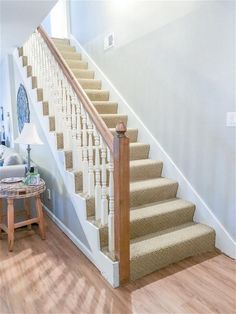 there is a white staircase with beige carpet on the bottom and handrails to the second floor