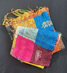 four pieces of cloth with different colors and designs on them, sitting next to each other