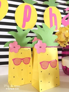 two pineapple bags with sunglasses on them