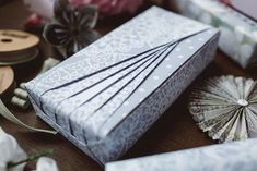 there are many different types of gift boxes on the table with ribbons and paper fans