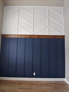 an empty room with blue painted walls and wood paneling on the wall, in front of a wooden floor