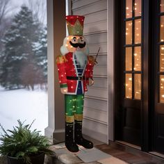 a lighted nutcracker standing in front of a house