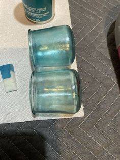 two blue cups sitting on top of a table next to a bottle of toothpaste