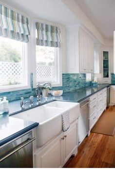 a large kitchen with white cabinets and blue counter tops on the counters is pictured in this image