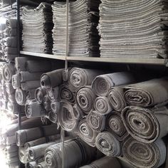 stacks of rolled up cloths on shelves in a store