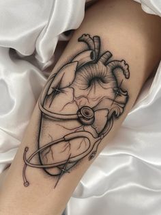 a black and white heart tattoo on the arm