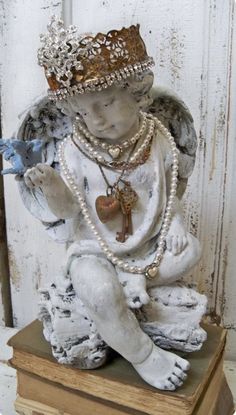 a statue of an angel sitting on top of a wooden box holding a blue bird