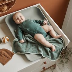 a baby is laying in a tray on the table