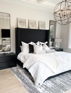 a bedroom with a large bed, chandelier and pictures on the wall above it