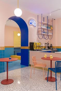 the interior of a restaurant with colorful tables and chairs