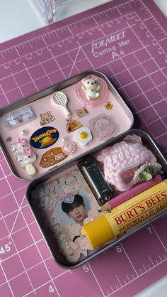 two tins filled with food on top of a pink cutting board next to a ruler