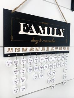 a family sign hanging from the side of a wall with calendars attached to it