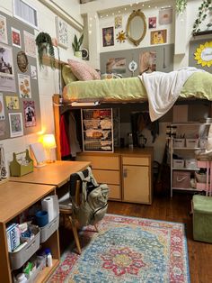 a dorm room with bunk beds, desks and other things on the wall above it