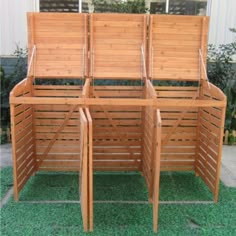 four wooden benches sitting next to each other on top of a green grass covered field