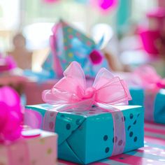 a blue gift box with a pink bow sitting on top of a striped table cloth