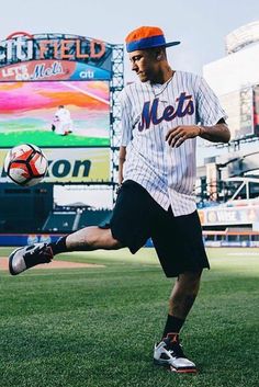 a man kicking a soccer ball on top of a field