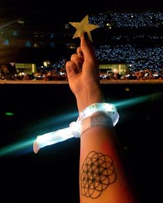 a person with a wrist tattoo holding up a star