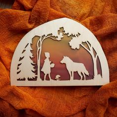 a wooden cutout of a boy and his dog in the woods, with trees