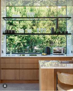 a kitchen with wooden cabinets and glass shelves