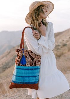 A show-stopping statement bag inspired by some of our favorite vintage designs. Our tie dye patchwork tote bag features a large tassel accent and a snap closure. FINAL SALE Mixed media patchwork Tie-dye Paisley Snap closure Large tassel accent Dimensions: 15" x 20"Style: DR-2105-2 Patchwork Hobo Tote Bag, Bohemian Cotton Canvas Shoulder Bag, Everyday Bohemian Cotton Hobo Bag, Bohemian Cotton Beach Bag For Travel, Blue Bohemian Tote Canvas Bag, Bohemian Square Shoulder Bag With Patchwork, Bohemian Cotton Shoulder Bag For Travel, Bohemian Cotton Shoulder Bag For Vacation, Blue Bohemian Canvas Tote Bag