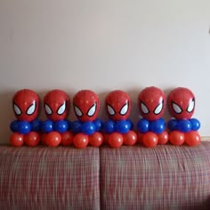 spiderman balloons lined up on a couch