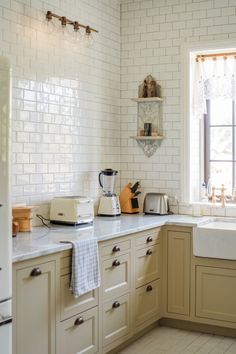 A bright, airy kitchen with cream-colored cabinets, subway tile backsplash, and modern appliances. Cabinet Color Schemes, Kitchen Cabinet Color Schemes, Stunning Kitchens