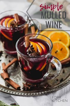 two glasses of mulled with cinnamon and orange slices