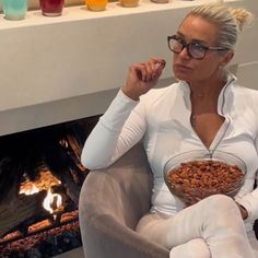 a woman sitting in a chair holding a bowl of food