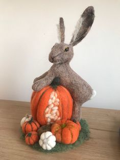 a stuffed rabbit sitting on top of a pile of pumpkins