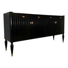 a black cabinet with gold knobs and legs