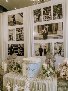 a wedding cake sitting on top of a table next to flowers and candles in front of pictures