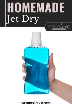 a hand holding a blue bottle with the words homemade jet dry on it and an image of