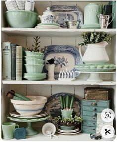 the shelves are filled with dishes and vases in blue, green and white colors