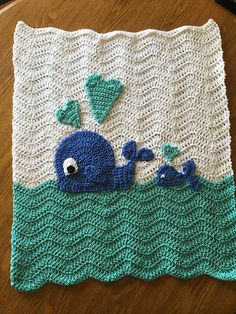 a crocheted blanket with a blue whale on it