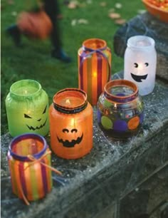 halloween candles are lined up on a stone ledge