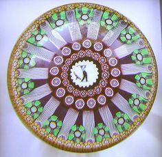 a decorative glass plate with an image of a person on the center and flowers in the middle