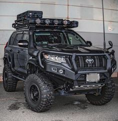 a black four - door suv parked in front of a building