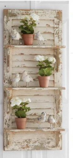 three wooden shelves with flowers and birds on them