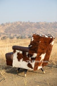 a brown and white chair sitting in the middle of a field