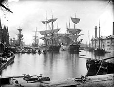 an old black and white photo of ships in the water