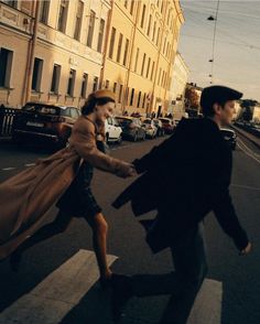 a man and woman walking across a cross walk