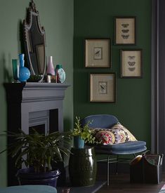 a living room with green walls and pictures on the wall, including a blue chair