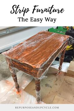 an old wooden table is covered in plastic and sits on the floor next to other pieces of wood