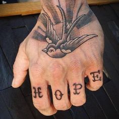 a person's hand with two birds and the word hope tattooed on it