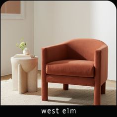 an orange chair sitting next to a white vase with a plant in it on top of a rug